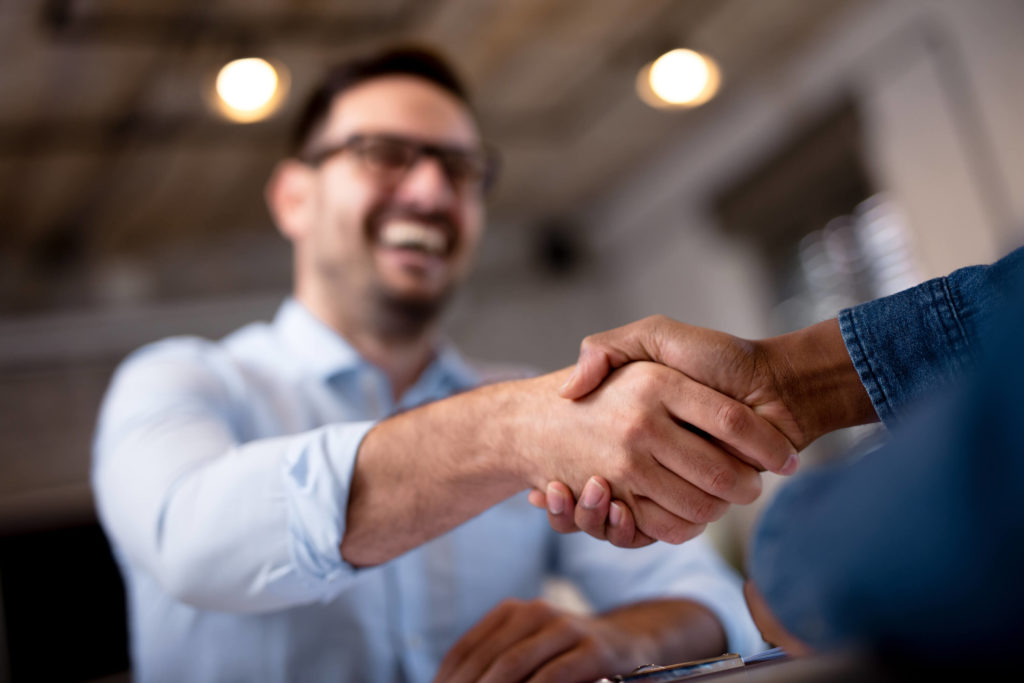 Office worker reaching out to shake hand